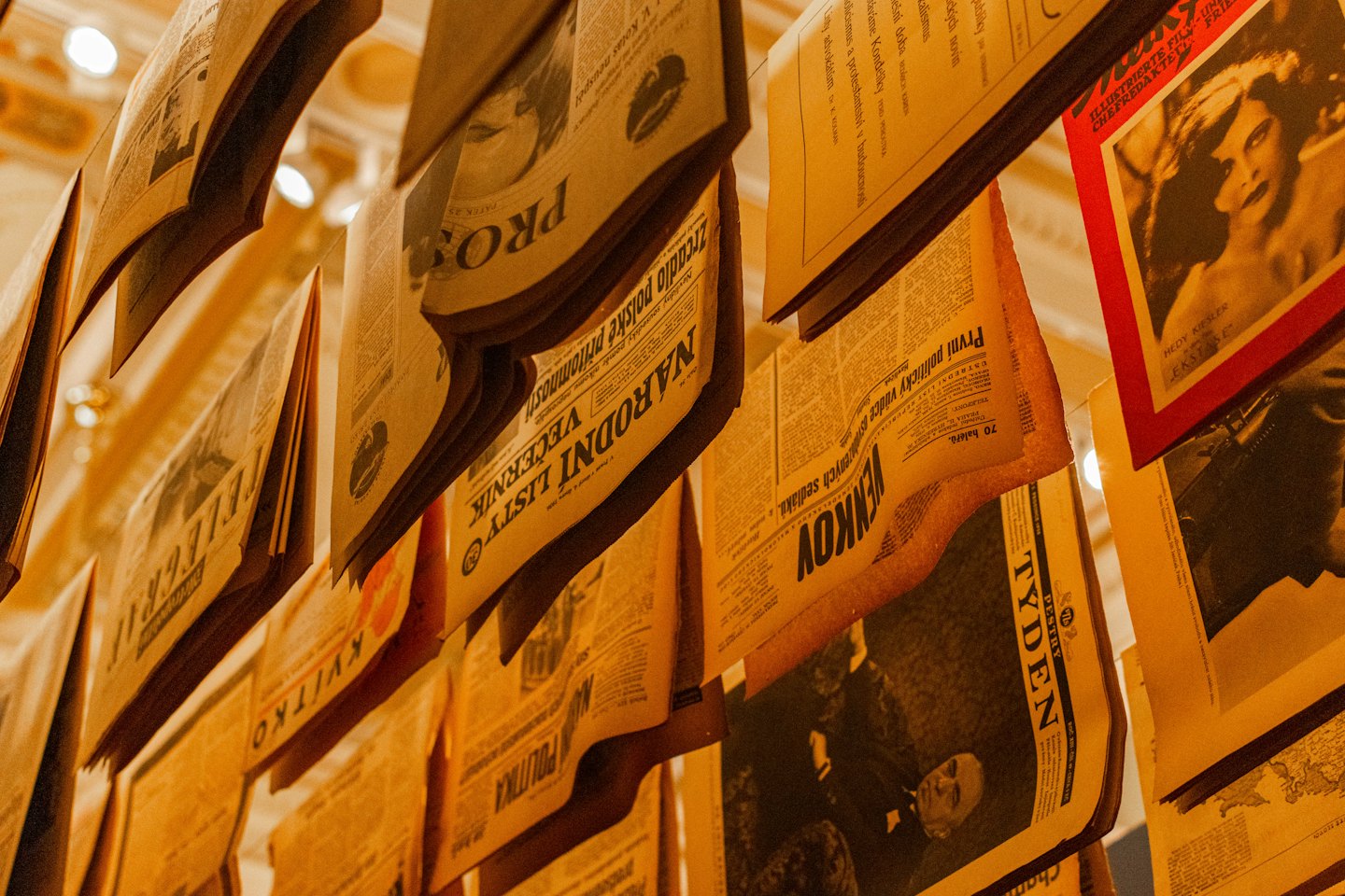 Vintage newspapers and magazines hang as an indoor art installation.